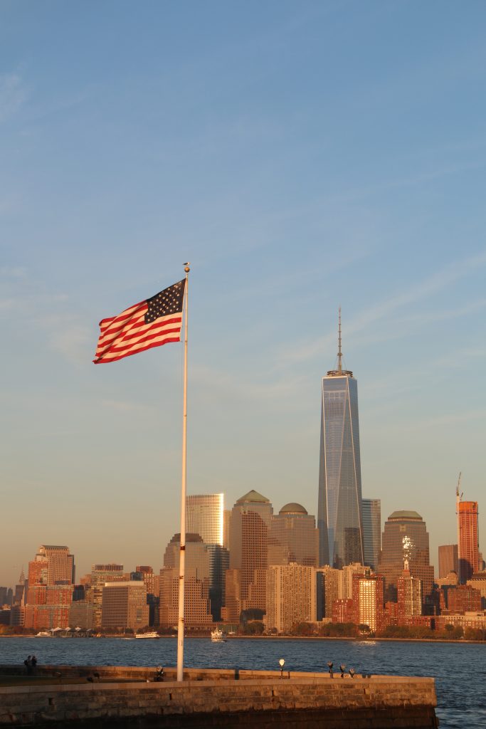 American Flag with cityscape in background